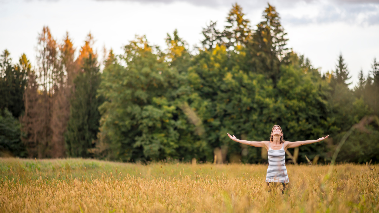 Woman Standing in the Middle of a Meadow